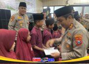 Kapolres Pelabuhan Tanjung Perak, AKBP Wahyu Hidayat menyerahkan santunan kepada anak yatim saat buka puasa Ramadan bersama media dan mahasiswa di Mapolres.