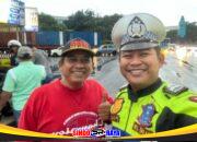 Anggota Satlantas Drajat berpose dengan warga saat pembagian takjil.