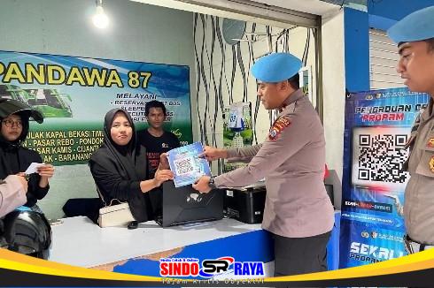 Plt Kasipropam Polres Bangkalan IPDA Rezaki menyerahkan selebaran QR Code Dumas Online kepada warga di Terminal Bangkalan.