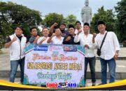 Kolaborasi Tiga Media di Surabaya memegang spanduk aksi bagi takjil gratis di Taman Apsari.