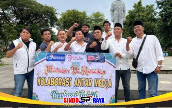 Kolaborasi Tiga Media di Surabaya memegang spanduk aksi bagi takjil gratis di Taman Apsari.