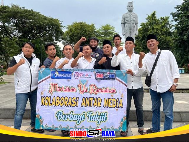 Kolaborasi Tiga Media di Surabaya memegang spanduk aksi bagi takjil gratis di Taman Apsari.