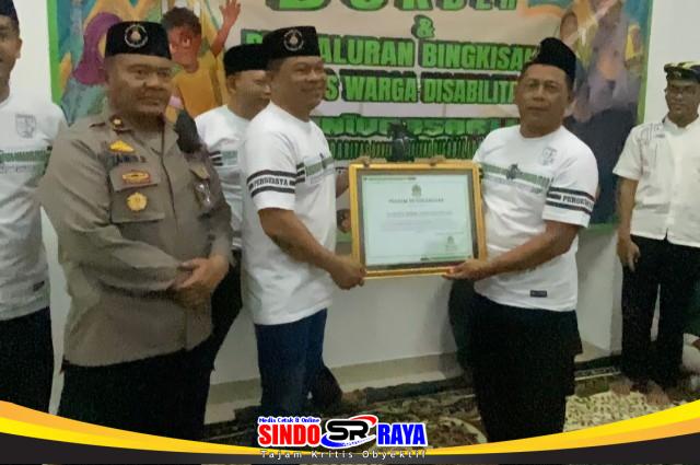 Kapolrestabes Surabaya Kombes Pol. Dr. Lutfi Sulisetiawan, S.I.K., M.H., serahkan piagam penghargaan kepada komunitas Bonek Peduli Disabilitas.