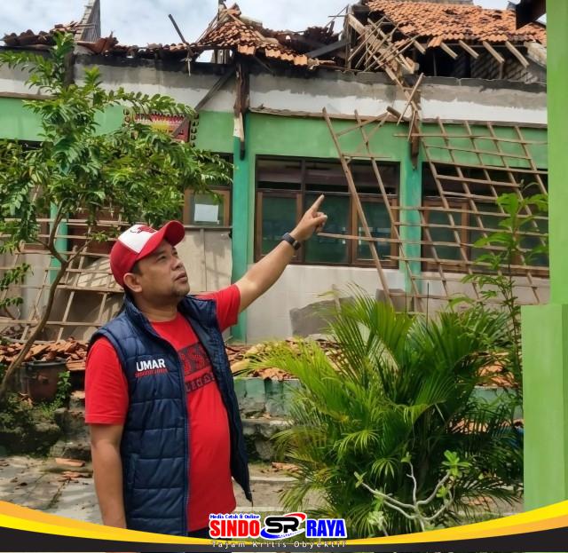 Ketua KWI Umar Hayat menunjuk atap bangunan SDN Rongtengah 5 Sampang yang roboh total.