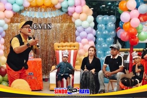 Badut tampil menghibur anak-anak pada perayaan ulang tahun ke-3 Kevin di KFC Delta Plaza Surabaya dengan latar dekorasi balon warna-warni.