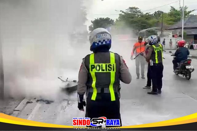 Satlantas Polres Gresik memadamkan motor terbakar di depan Terminal Bunder akibat dugaan korsleting listrik