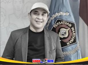 Sekjen PWI Pusat Zulmansyah Sekedang semasa hidup berpose di depan bendera Persatuan Wartawan Indonesia (PWI)