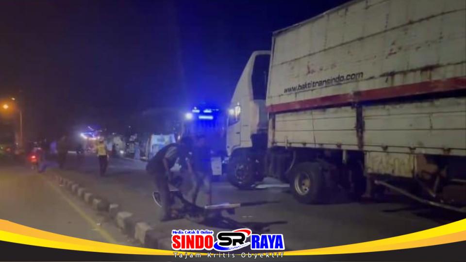 Petugas kepolisian mengevakuasi truk trailer terguling di Jalan Raya Kebalandono, Babat, Lamongan.