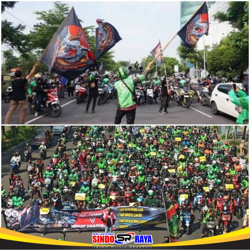 Ribuan driver ojol mengikuti demo akbar di Surabaya sambil membawa bendera dan kendaraan untuk menuntut regulasi transportasi online.
