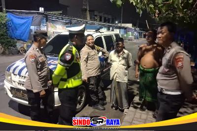 Personel Polres Pelabuhan Tanjung Perak memberikan sosialisasi antisipasi banjir rob kepada warga pesisir Surabaya pada malam hari.