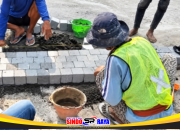 Pekerja menata paving atau batu alam di kawasan depan MPP Siola, Surabaya.