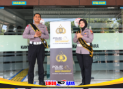 Dua petugas polisi di Samsat Surabaya Utara dengan spanduk Polisi Bersama Masyarakat.